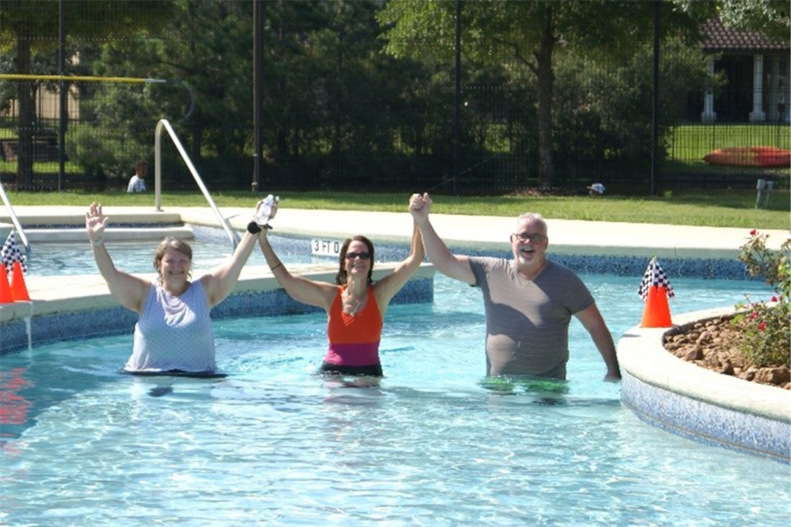 Photo of three people walking in a pool