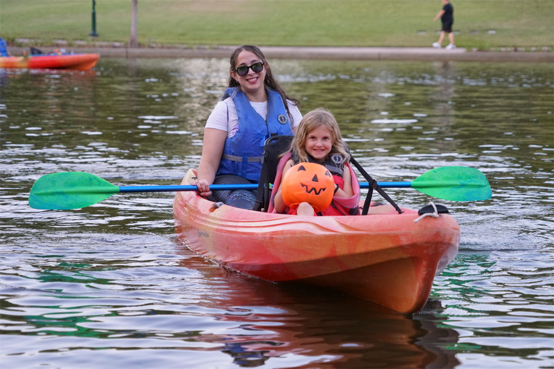 Photo of an adult and child in an orange kayak