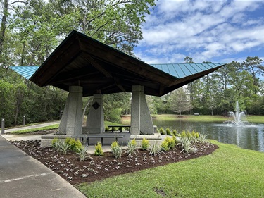 Photo of a concrete pavilion surrounded by plants