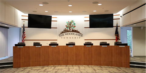 Photo of a Boardroom with a wooden dias and black chairs