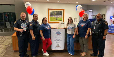 Police officers and Township employees standing in a lobby smiling