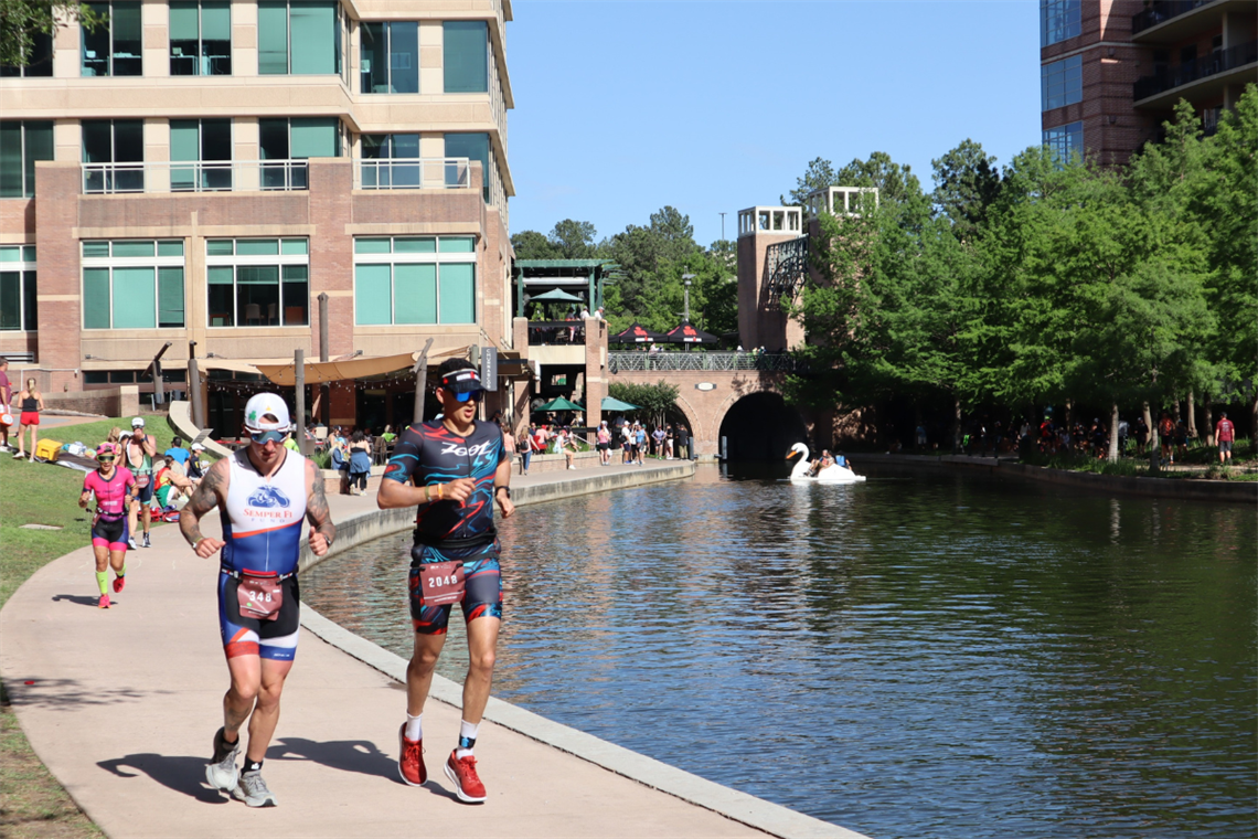 IRONMAN race runners running along side a water-filled canal