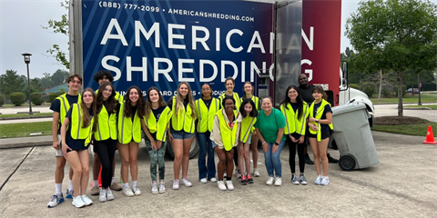 A group of young adults standing in front of an 