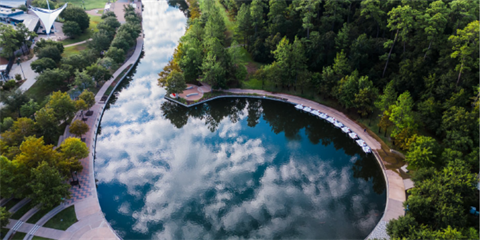 A round turning basin in a waterway surrounded by green trees.