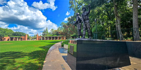 The way Home Memorial. A black granite base with two soldiers standing on top. Monument is surrounded by green grass