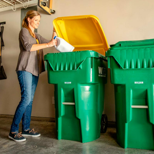 Woman putting a plastic jug into a WM recycling cart
