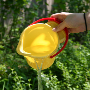 Yellow bucket of water being dumped outside