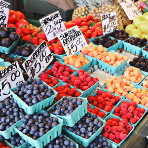 Assorted berries for sale on a table in containers