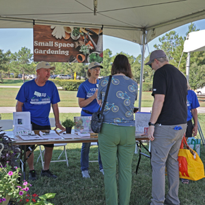 People at a gardening educational booth talking