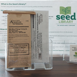 Soil testing bags in a stand with a seed library sign behind it