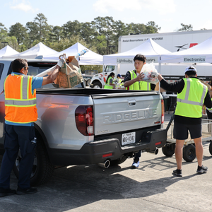 Volunteers in vests unloading recyclables from a truck
