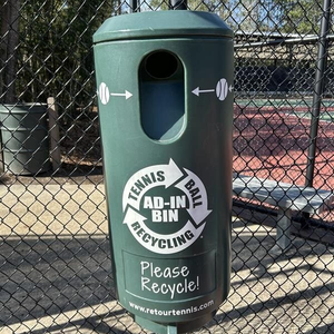 Tennis ball recycling receptacle affixed to a fence