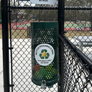 Pickleball recycling receptacle affixed to a fence