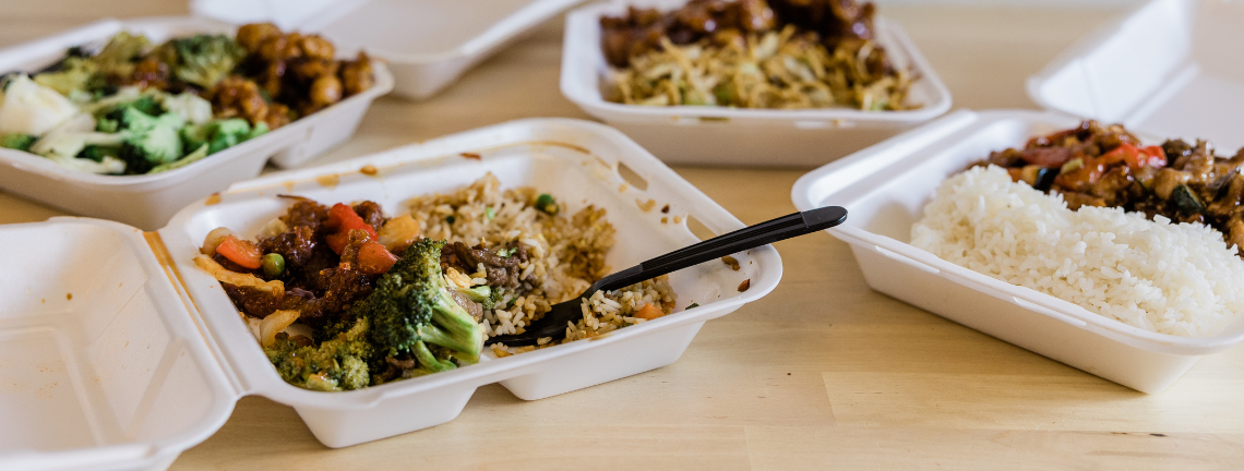 A collection of styrofoam food takeout containers with food inside