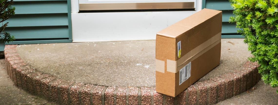 A cardboard box package on a front door step