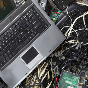 Laptops, cords, and assorted electronics in a pile