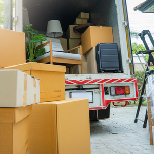 Moving truck with various items in it and boxes in front of it