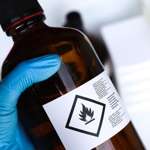 Person holding a glass bottle with a flame graphic on its label