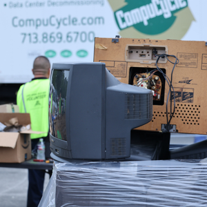 TV and speaker on top of a pallet of electronics with a CompuCycle truck in the background