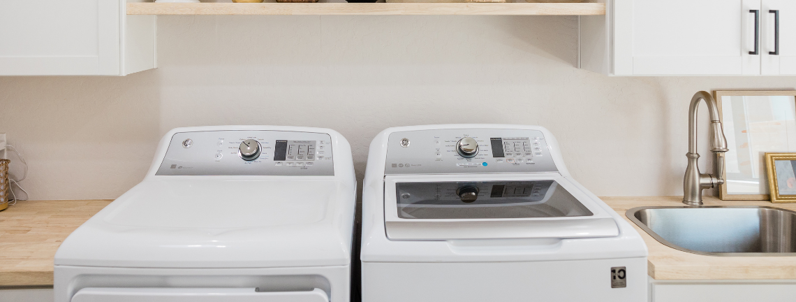 A view of a laundry room with a water and dryer next to a sink