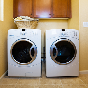 Washer and dryer in a laundry room with a basket of laundry on the washer