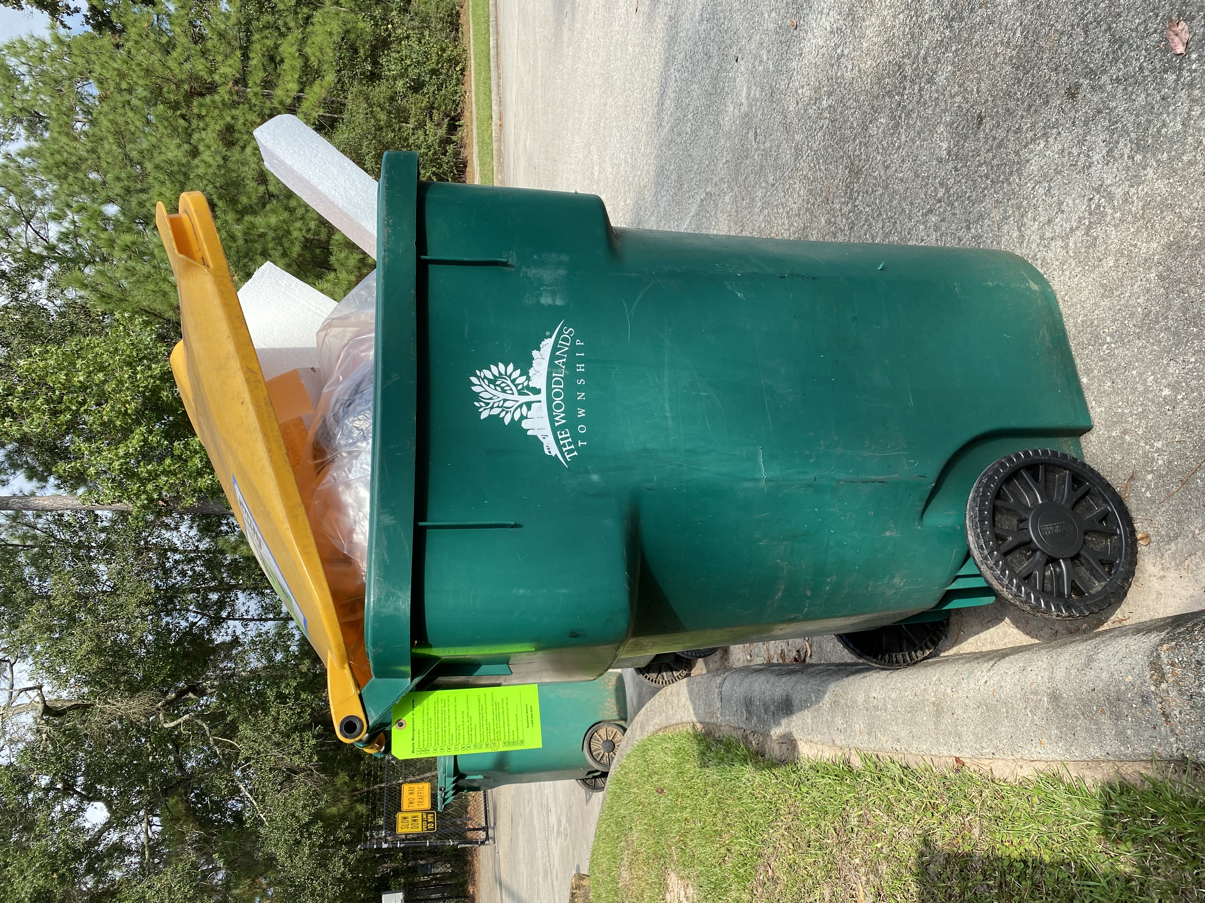 a trash bin with a green tag attached