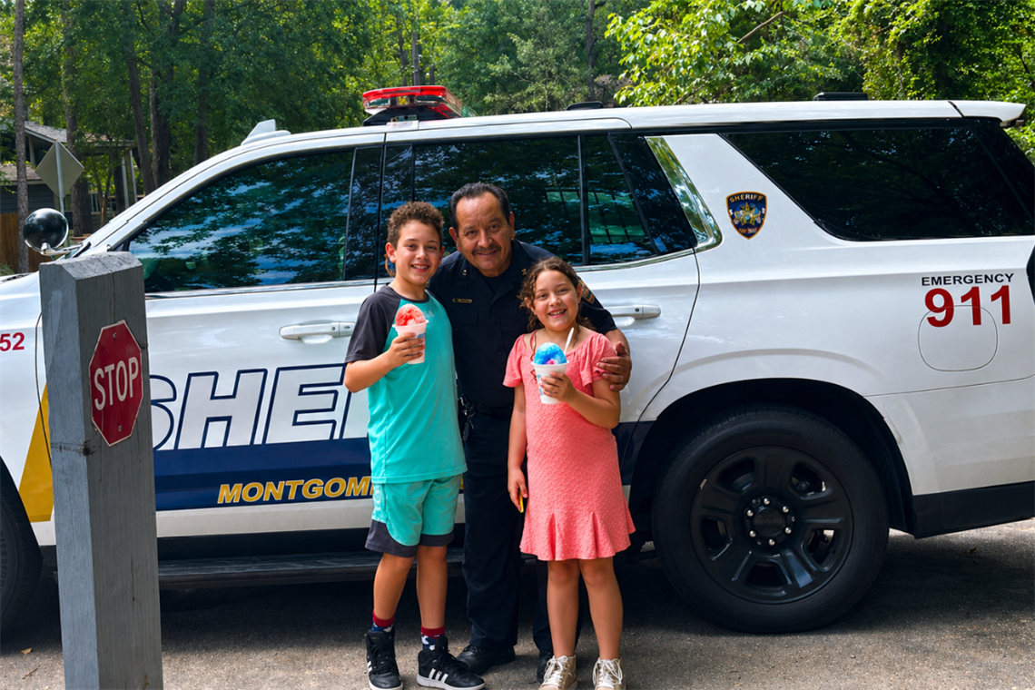 Friendly police officer with children holding snow cones