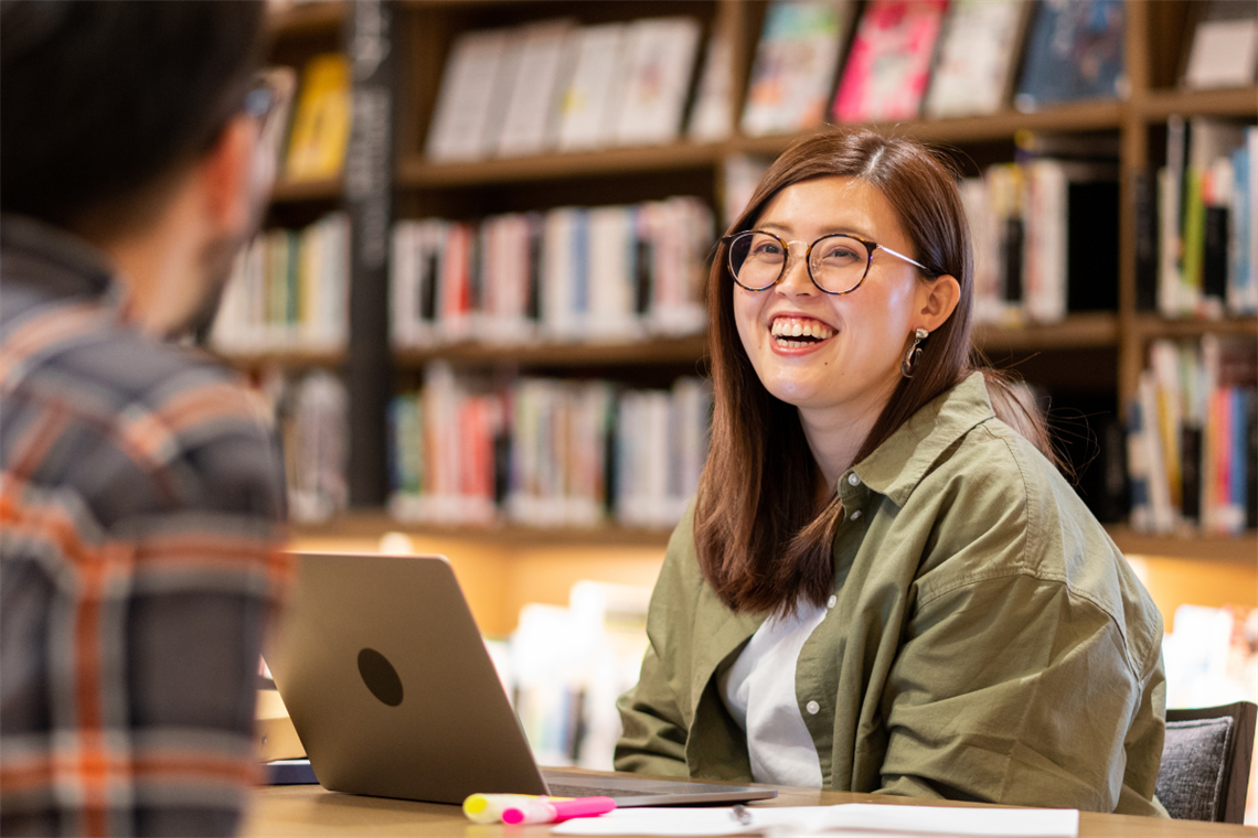 Young smiling adult sitting in a library