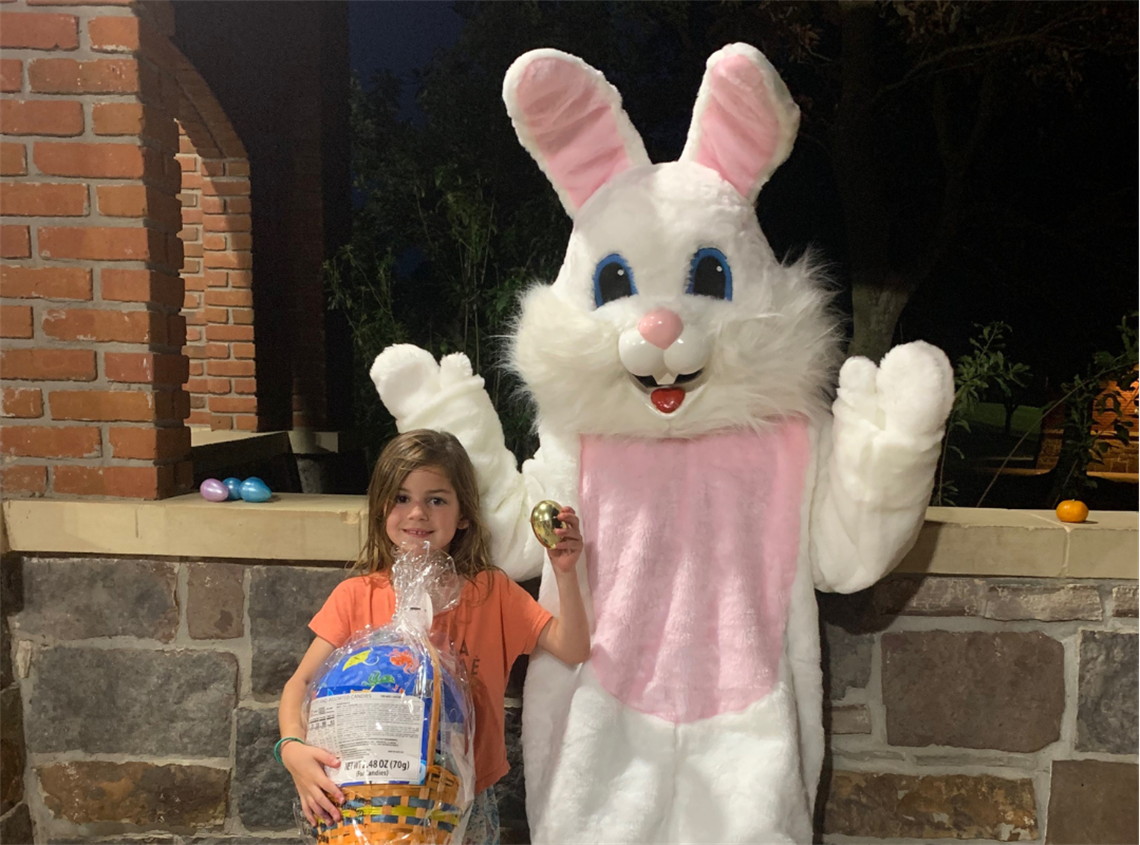 Photo of child standing with the Easter Bunny