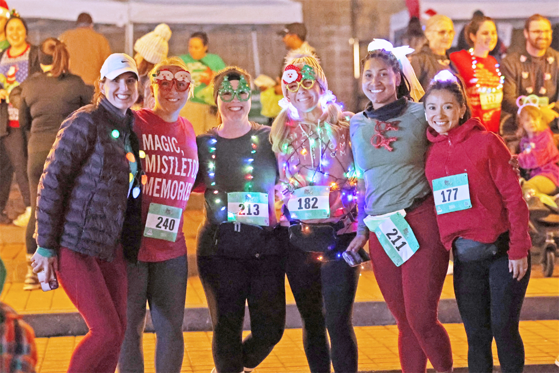 Photo of race participants wearing holiday glasses and twinkle lights