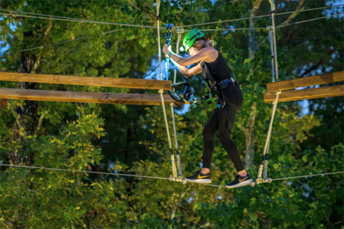 Photo of a person climbing on the adventure ropes course