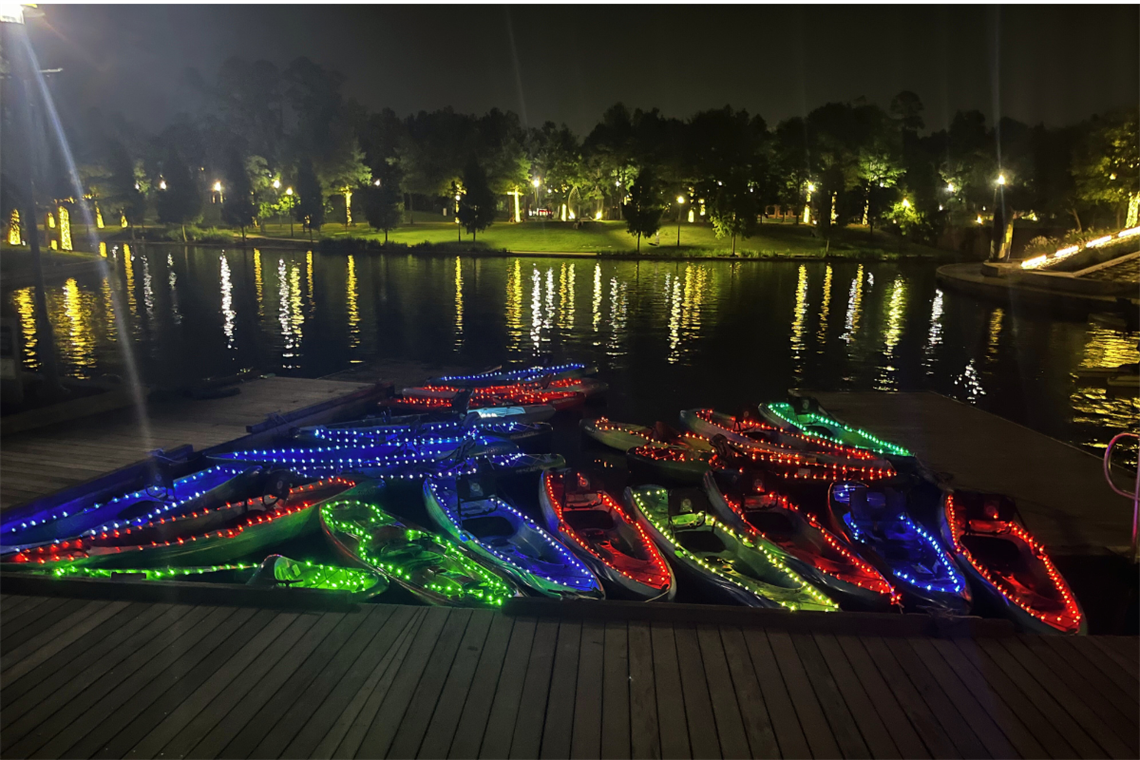 Photo of kayaks on the water with string lights